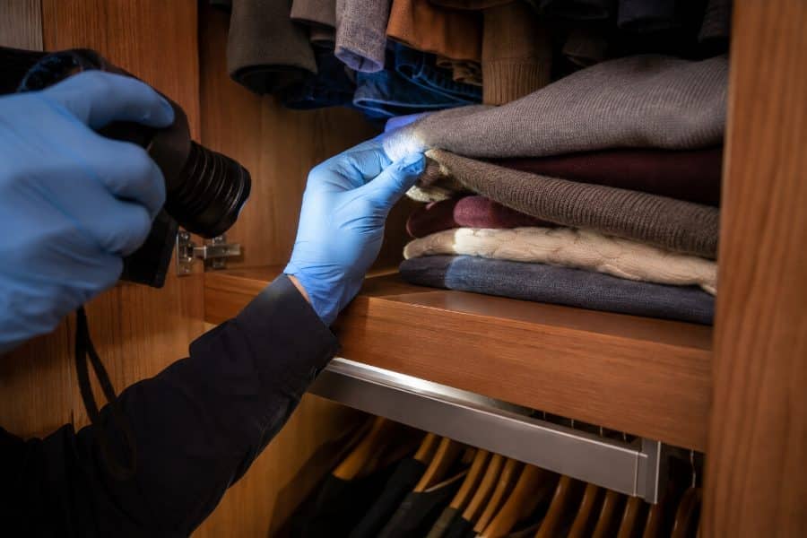 Controllo dei vestiti e dei ripiani dell’armadio con una torcia