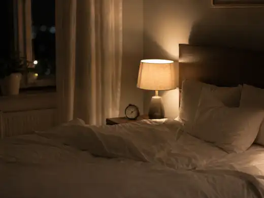 Camera da letto di notte con lampada accesa che suggerisce risveglio per prurito