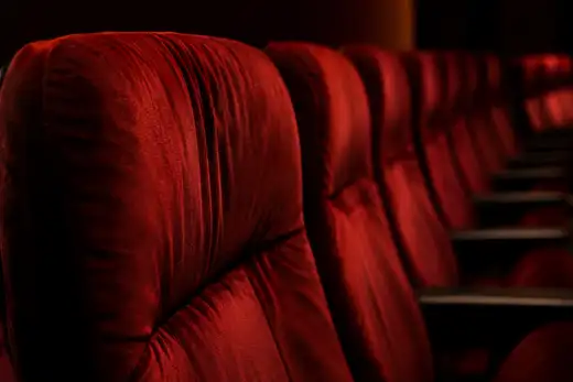 Poltrone in velluto rosso di una sala cinema, nascondiglio ideale per le cimici dei letti nelle cuciture