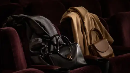 Mäntel und Taschen an der Garderobe eines Kinosaals