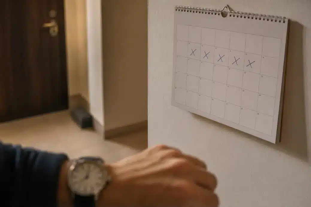 Wandkalender mit markierten Tagen und einer nummerierten Falle im Hintergrund