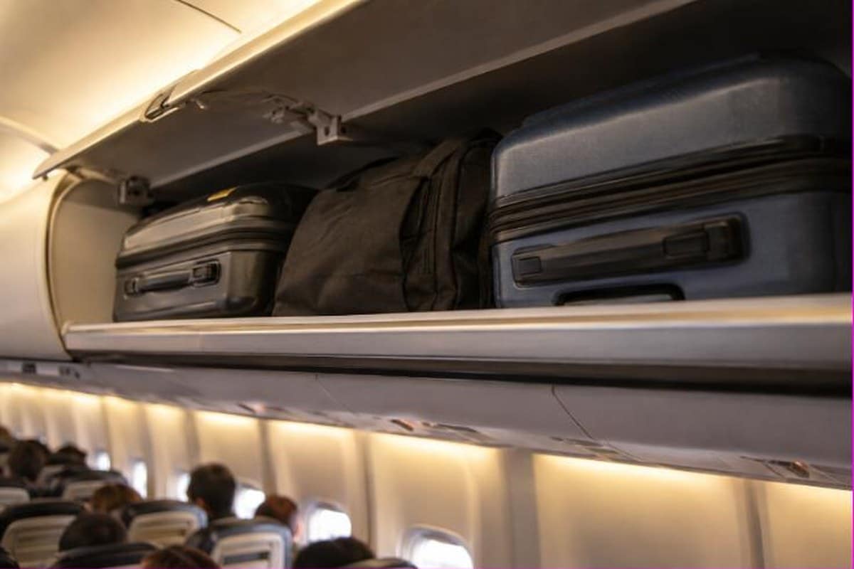 Bagagli a mano stipati a contatto nella cappelliera di un aereo